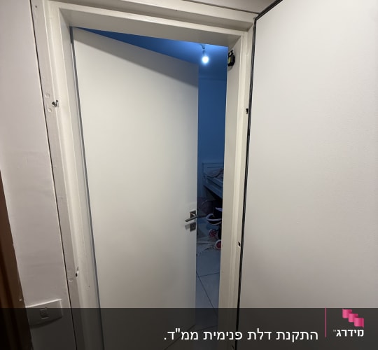 דלת לבנה פתוחה עם ידית מתכת